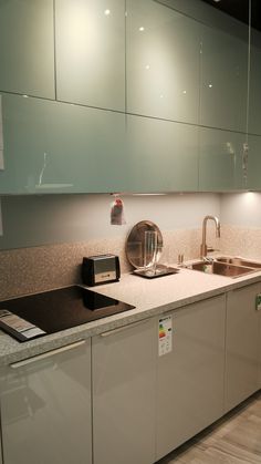 a kitchen with white cabinets and stainless steel appliances on the counter top, along with a sink