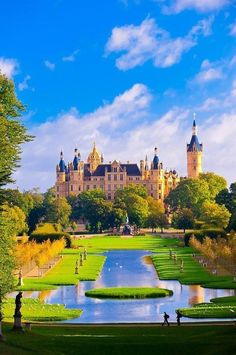 a large castle with a pond in front of it