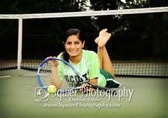 a woman sitting on top of a tennis court holding a racquet in her hand