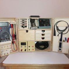 an assortment of electrical equipment is displayed in a box on a table with wires and other items