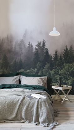 a bedroom with a forest mural on the wall next to a bed and night stand