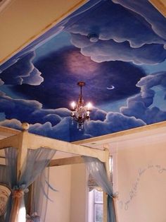 a bedroom with a painted ceiling and chandelier hanging from the ceiling above it