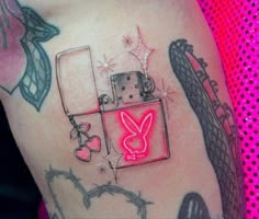 a woman's thigh with tattoos on it and a pink light in the shape of a heart