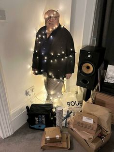 a man standing next to boxes and speakers