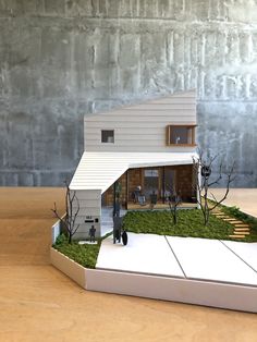 a model of a house sitting on top of a wooden table