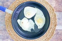 fried eggs are in a frying pan on the table