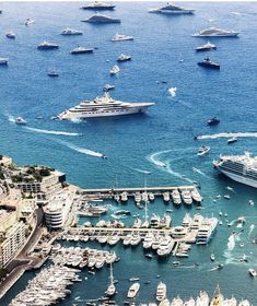 many boats are in the water near some buildings and yachts that are docked together