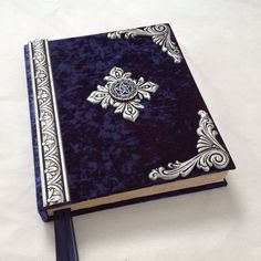 a blue and white book with an ornate design on the cover is sitting on a table