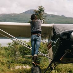 a woman standing on the wing of an airplane