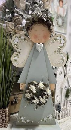 an angel figurine sitting on top of a table next to a potted plant