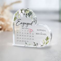 a personalized glass heart shaped calendar on a table