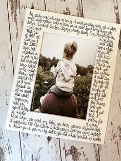 a wooden frame with writing on it and a child sitting on the back of it