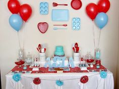 a table topped with red, white and blue desserts next to balloons in the shape of hearts