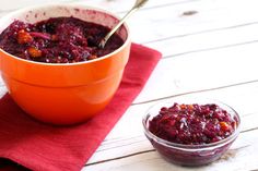 a bowl of cranberry sauce with a spoon in it next to another bowl