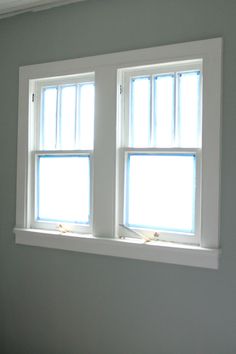 two windows in a room with white walls