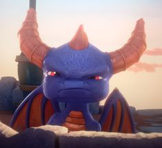 an animated blue dragon with large horns and red eyes standing in front of a stone wall