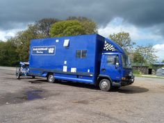 a blue truck with a checkered flag on it's side parked in a parking lot