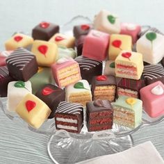 a glass plate filled with lots of different types of cakes