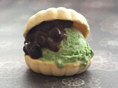 an ice cream sandwich with chocolate sauce and green icing on it's bun