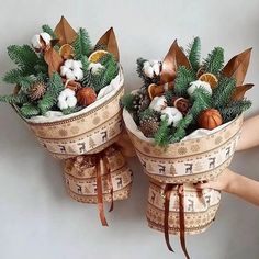 two baskets filled with different types of christmas decorations on top of each other and wrapped in ribbon