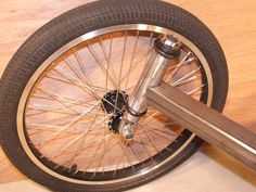 a close up of a bike wheel on a wooden floor