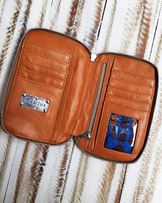 an open wallet sitting on top of a wooden table