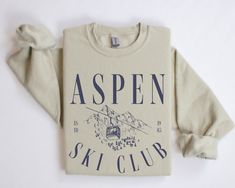 the aspen ski club sweatshirt is on display in front of a white background with blue writing