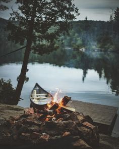 a boat sitting on top of a lake next to a fire