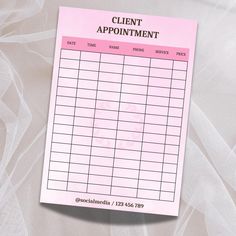 a pink and white appointment card on top of a sheet of paper that says client appointment