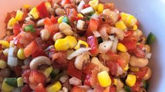 a white bowl filled with corn and vegetables