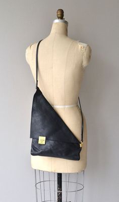 a mannequin with a black leather purse on it's back and shoulder strap