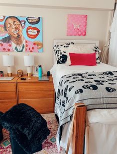 a bed room with a neatly made bed and paintings on the wall