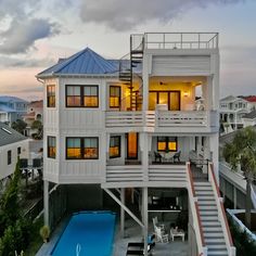 an aerial view of a house with a pool in the foreground and stairs leading up to it