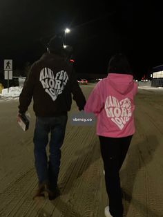 two people walking down the street at night