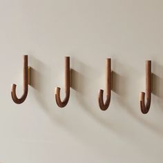 three wooden hooks are hanging on the wall