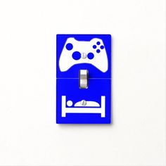 a blue and white light switch cover with a video game controller on it's side