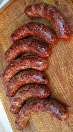 several sausages on a cutting board ready to be cooked