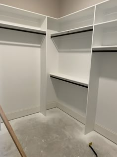 an empty walk in closet with white walls and open shelvings on the floor