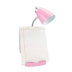 a pink desk lamp sitting on top of a piece of paper next to a note pad