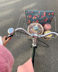 a person riding a bike with a purse on the back basket and other items in front of them