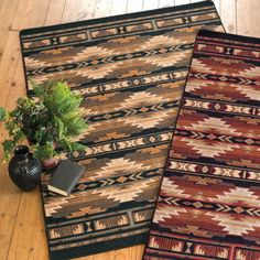 two rugs sitting on top of a hard wood floor next to a potted plant