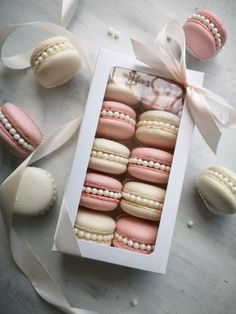 a box filled with macaroons covered in pink and white frosting