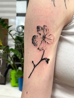 a woman's arm with a flower tattoo on the left side of her arm