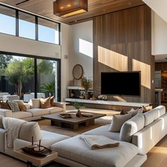 a living room filled with furniture and a flat screen tv mounted on the wall above it