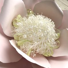 a large white flower sitting on top of a wooden table