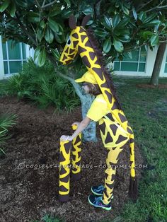 a person in a giraffe costume standing next to a tree