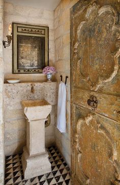 the bathroom is decorated in stone and has a checkered flooring pattern on the tile