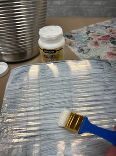 a paintbrush sitting on top of a piece of tin foil next to a can