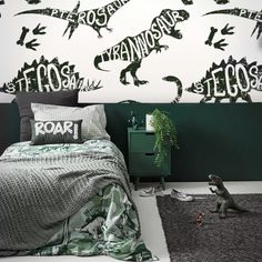 a bedroom with dinosaur stencils on the wall and rugs in front of it