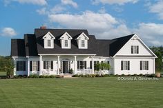 a large white house with black roof and windows